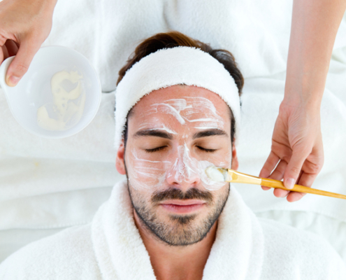 A relaxed man receiving a detox facial treatment at a med spa.