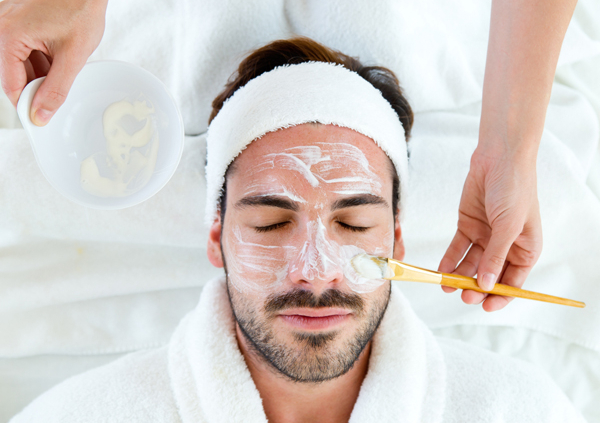 A relaxed man receiving a detox facial treatment at a med spa.