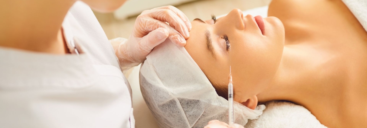 Medical professional injecting a client’s forehead during a facial rejuvenation procedure.